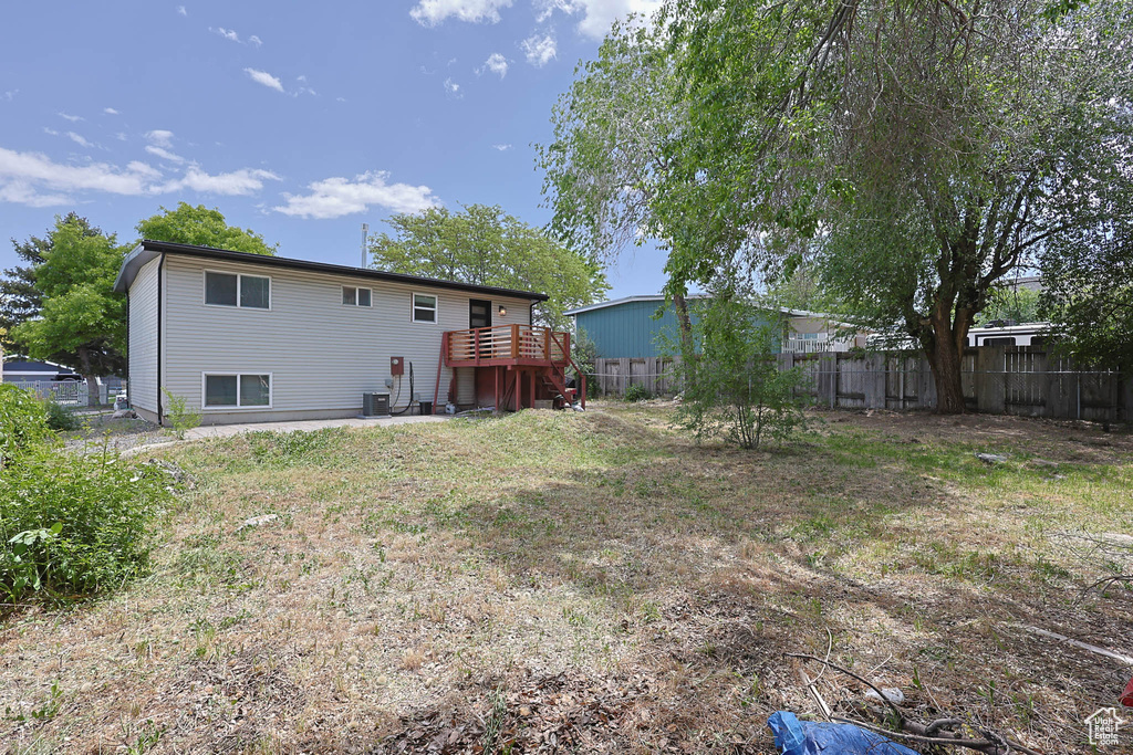 Rear view of house with a deck and central AC unit