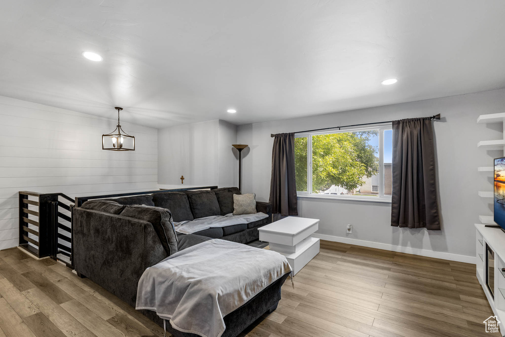 Living area featuring wood finished floors, recessed lighting, a chandelier, and baseboards