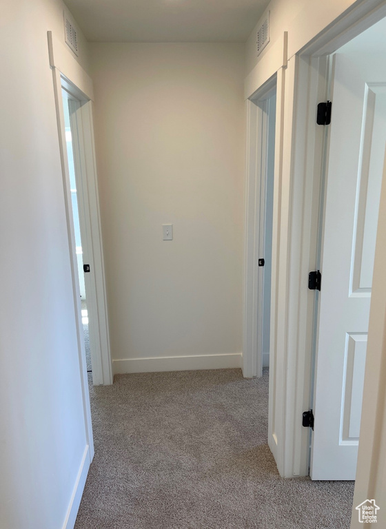 Hallway with carpet and baseboards