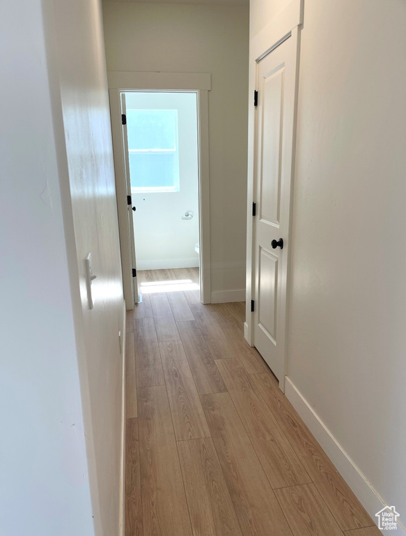 Corridor with wood finished floors and baseboards