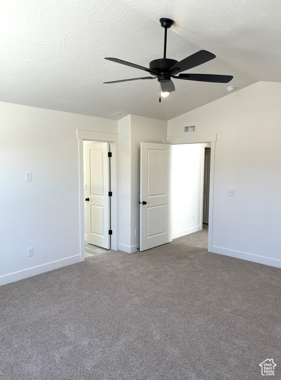 Unfurnished bedroom with light carpet, baseboards, lofted ceiling, and a ceiling fan