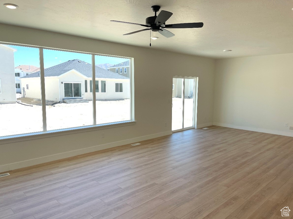Unfurnished room featuring light wood-style flooring, ceiling fan, baseboards, and recessed lighting