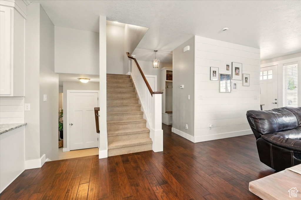 Living room featuring dark wood finished floors, stairway, and baseboards