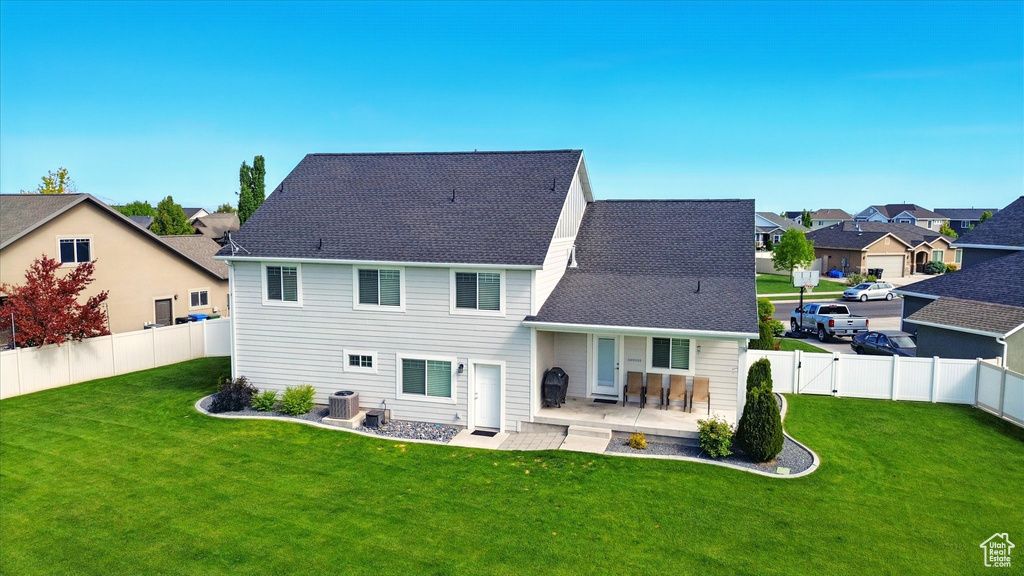 Rear view of property with a residential view, central air condition unit, a patio, and a shingled roof