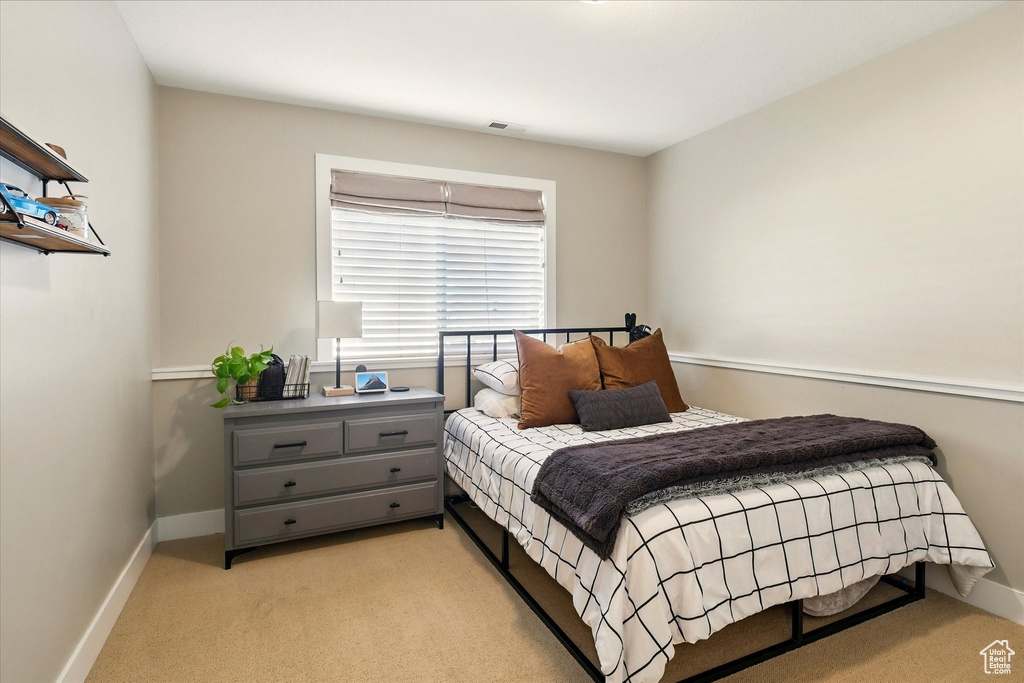 Bedroom with light colored carpet and baseboards