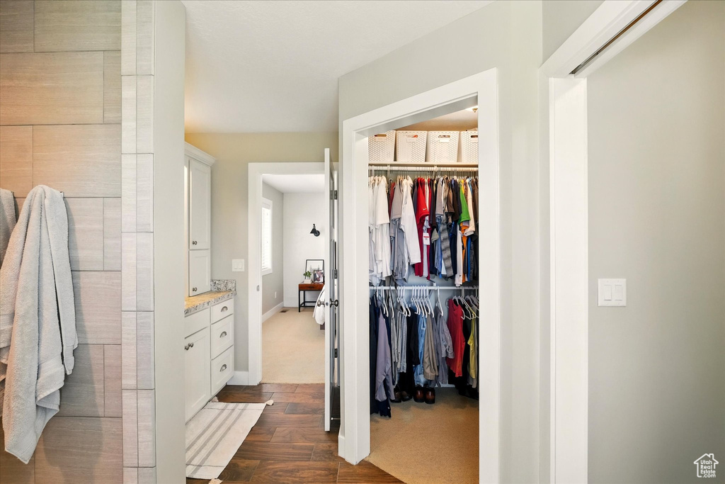 Spacious closet with dark wood-style floors