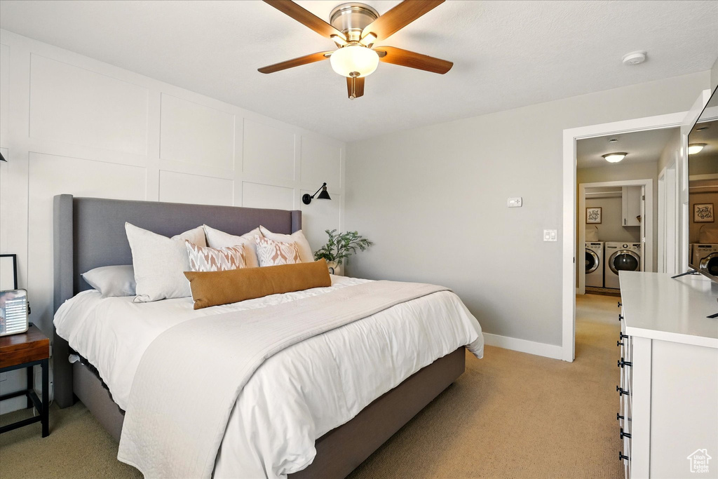 Bedroom with washer and dryer, light carpet, ceiling fan, and baseboards