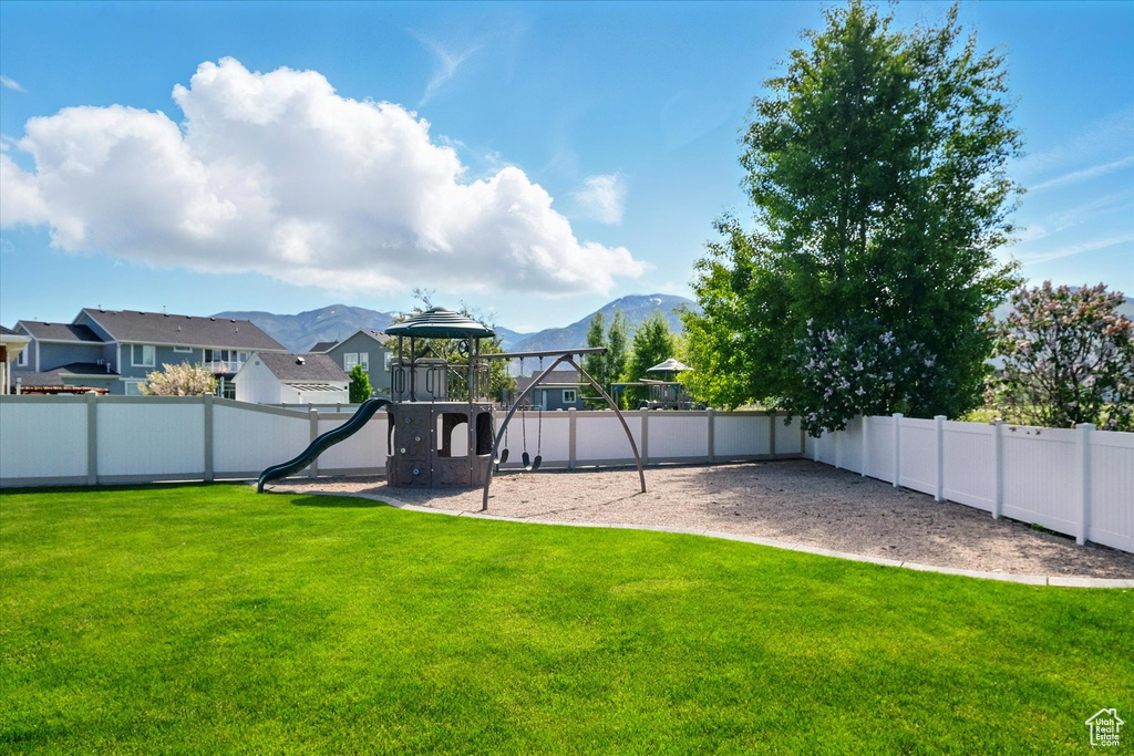 View of yard with a playground, a mountain view, and a residential view