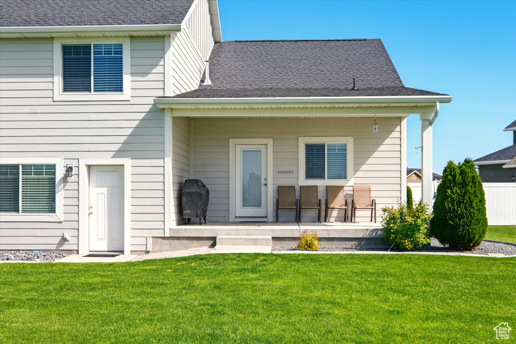 Rear view of property with a yard and a shingled roof