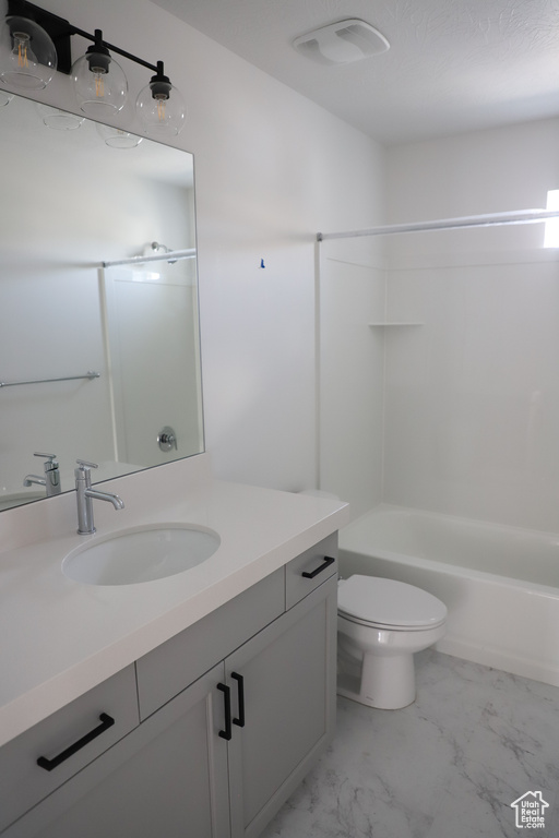 Full bath featuring marble finish flooring, vanity, toilet, and  shower combination