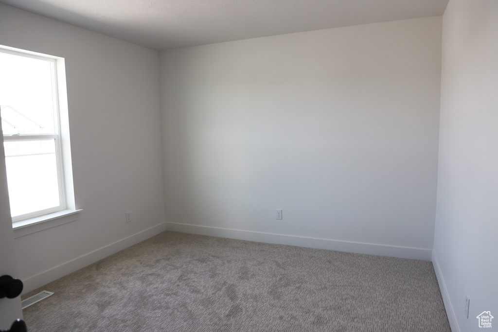 Carpeted empty room with baseboards