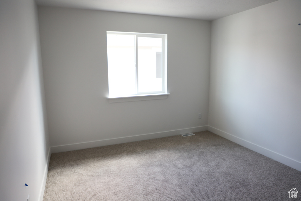 Empty room with carpet floors and baseboards