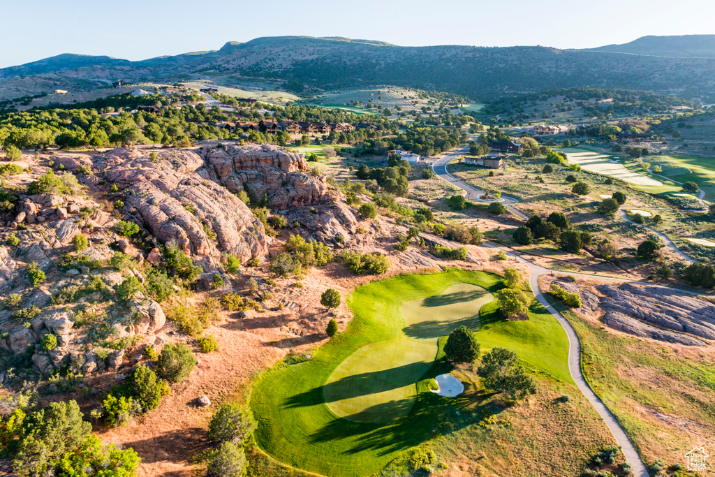Aerial view of property and surrounding area with a mountainous background and a golf course