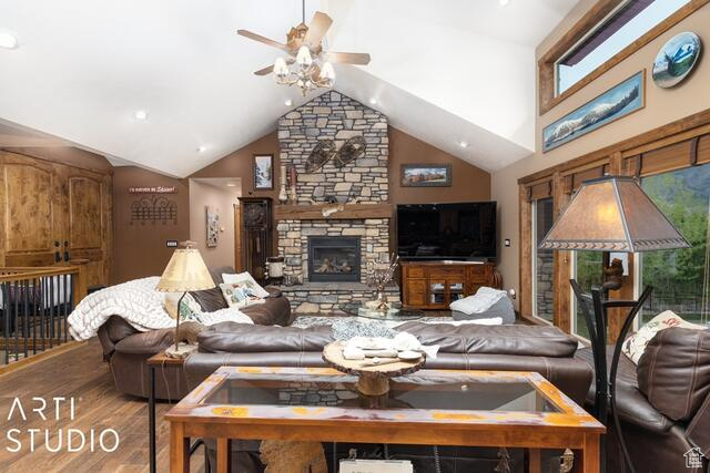 Living area featuring ceiling fan, a fireplace, wood finished floors, vaulted ceiling, and recessed lighting