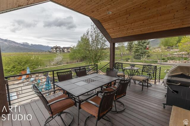 Deck with outdoor dining area and a mountain view