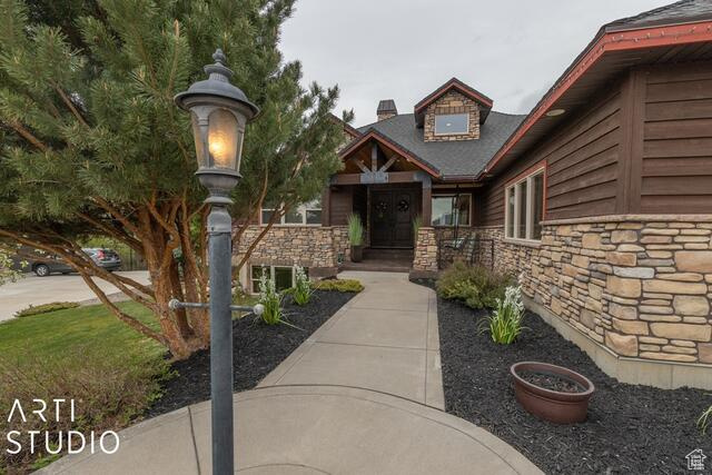 View of exterior entry featuring stone siding and a chimney