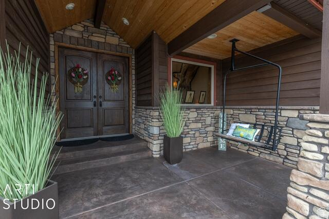Property entrance featuring stone siding and french doors
