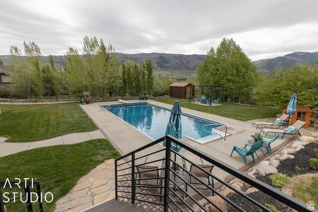 View of pool with a patio area and a mountain view
