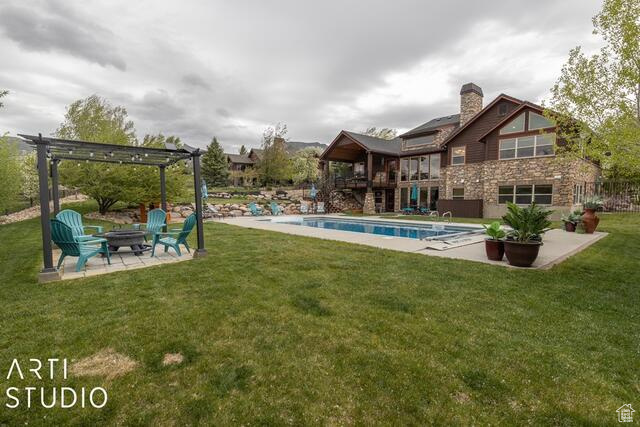 Swimming pool with a pergola, a fire pit, a patio, and a yard