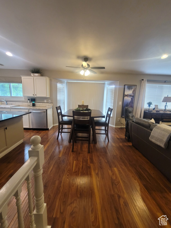 Dining room featuring dark wood-type flooring, a ceiling fan, baseboards, and recessed lighting