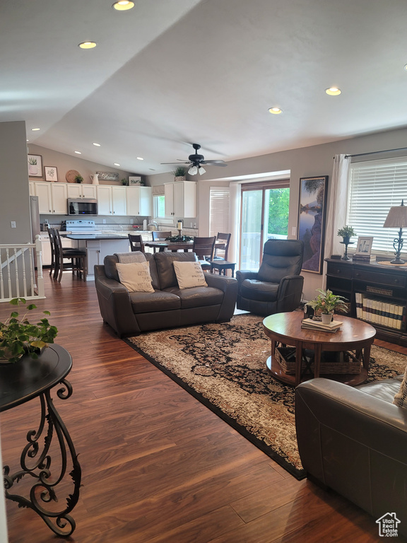 Living room with vaulted ceiling, dark wood-style floors, ceiling fan, and recessed lighting