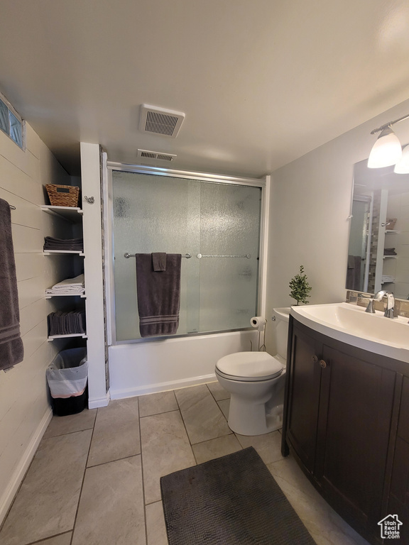 Full bath featuring vanity, toilet, enclosed tub / shower combo, and tile patterned flooring