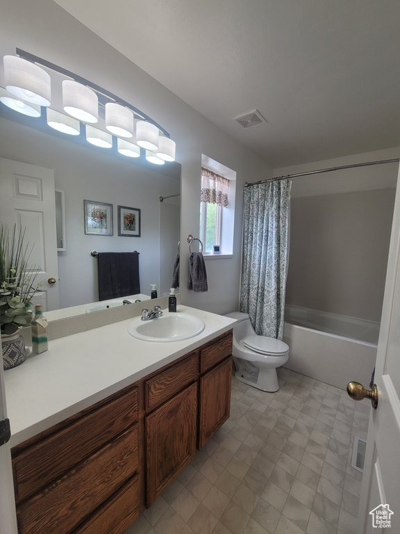 Bathroom with vanity, toilet, and shower / bath combo with shower curtain