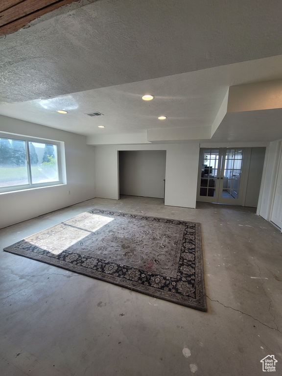 Basement with recessed lighting and a textured ceiling