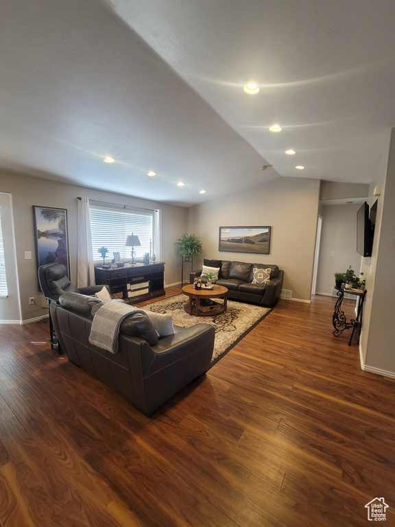 Living area featuring dark wood-style flooring, lofted ceiling, baseboards, and recessed lighting