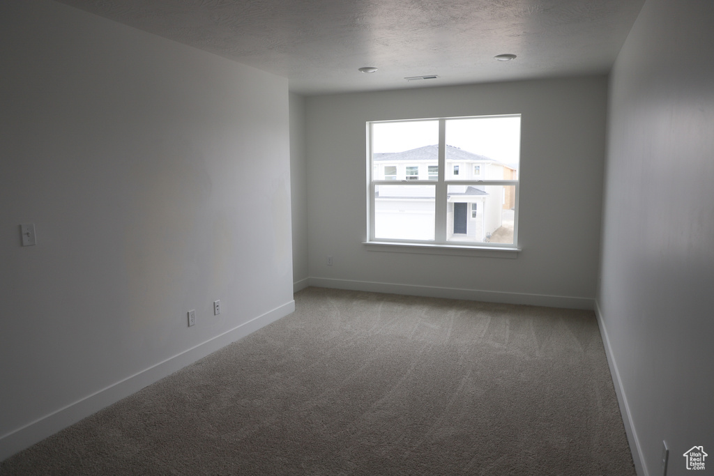 Unfurnished room with light carpet and baseboards