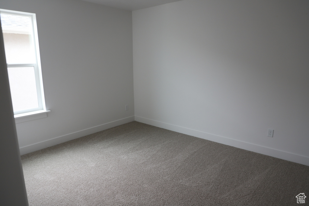 Spare room featuring carpet floors and baseboards