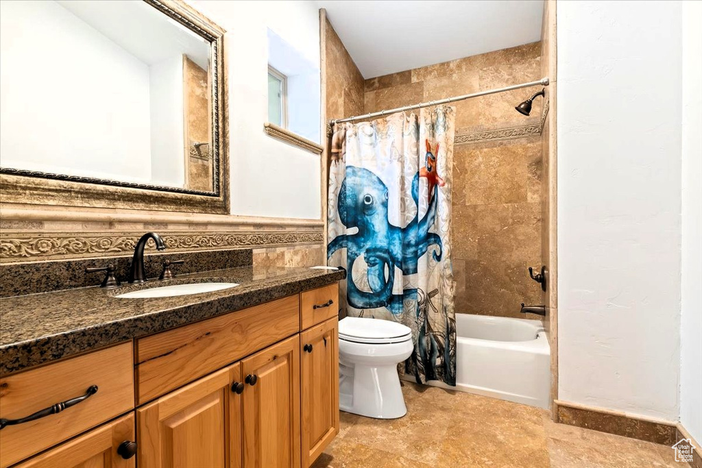 Full bathroom with toilet, vanity, and shower / bath combination with curtain