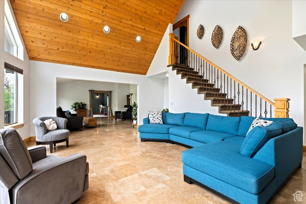 Living area with high vaulted ceiling, stairs, wood ceiling, and recessed lighting