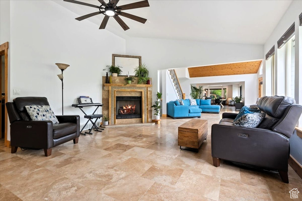 Living room with high vaulted ceiling, ceiling fan, and a high end fireplace