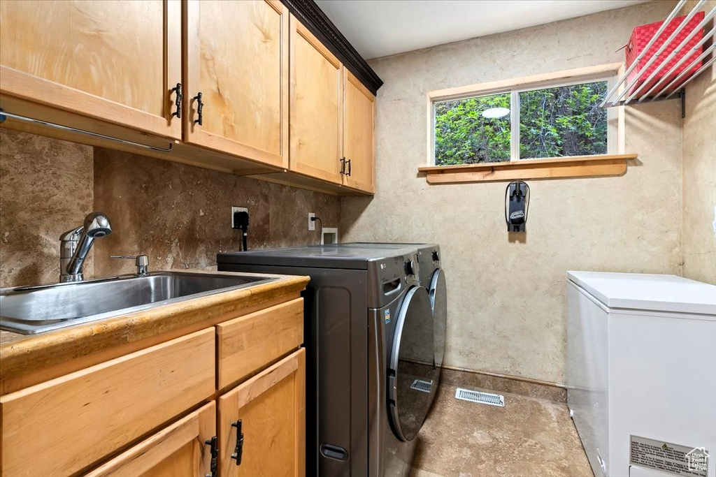 Laundry room featuring cabinet space and washer and clothes dryer