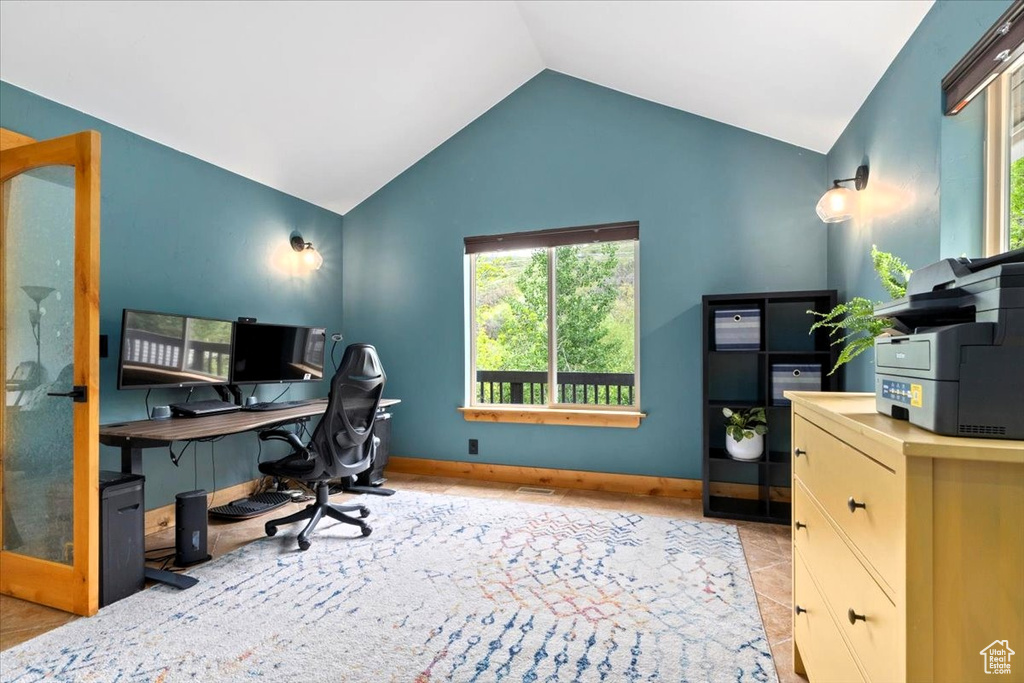 Tiled office space with lofted ceiling and baseboards