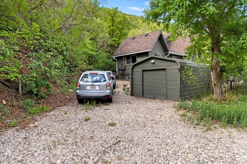 View of front of property with a shingled roof and a garage