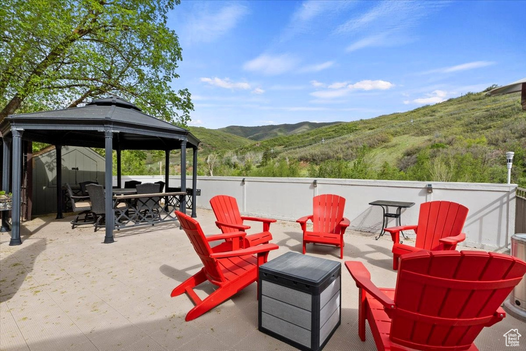 View of patio / terrace with a mountain view, a gazebo, an outdoor fire pit, and outdoor dining space
