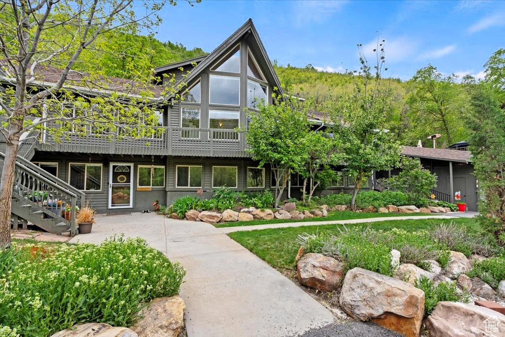 View of front of home featuring stairway and a wooden deck