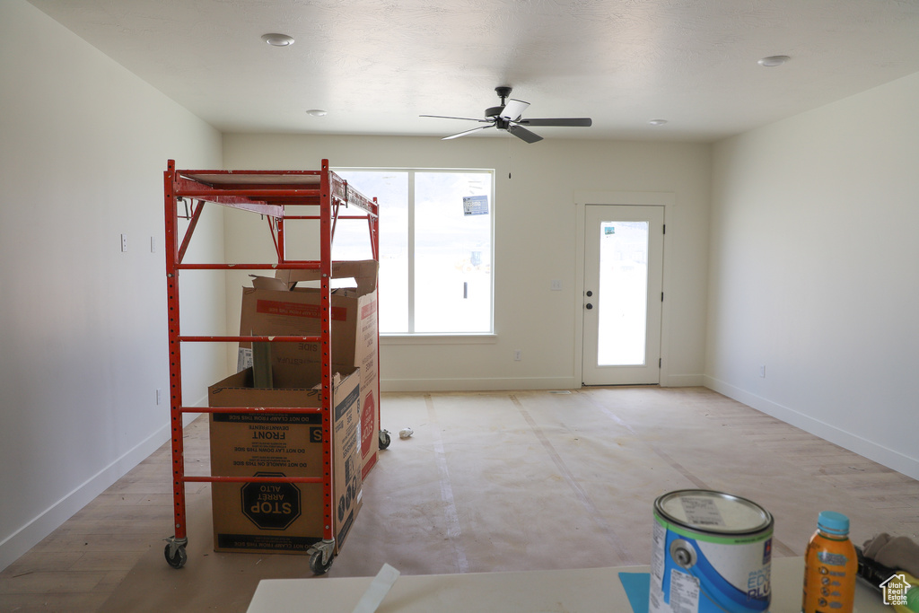 Foyer with ceiling fan and baseboards