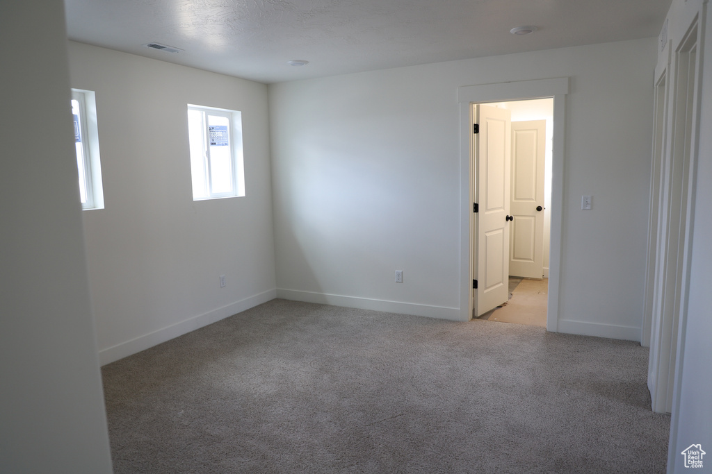 Unfurnished room featuring light colored carpet and baseboards
