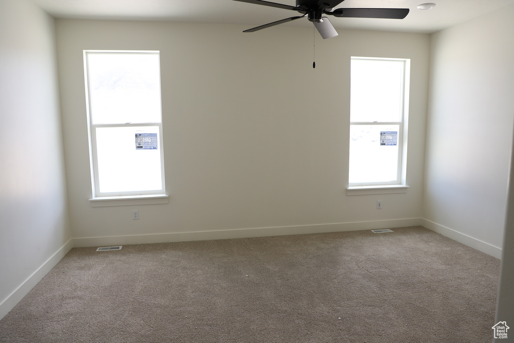 Empty room featuring ceiling fan, carpet floors, and baseboards