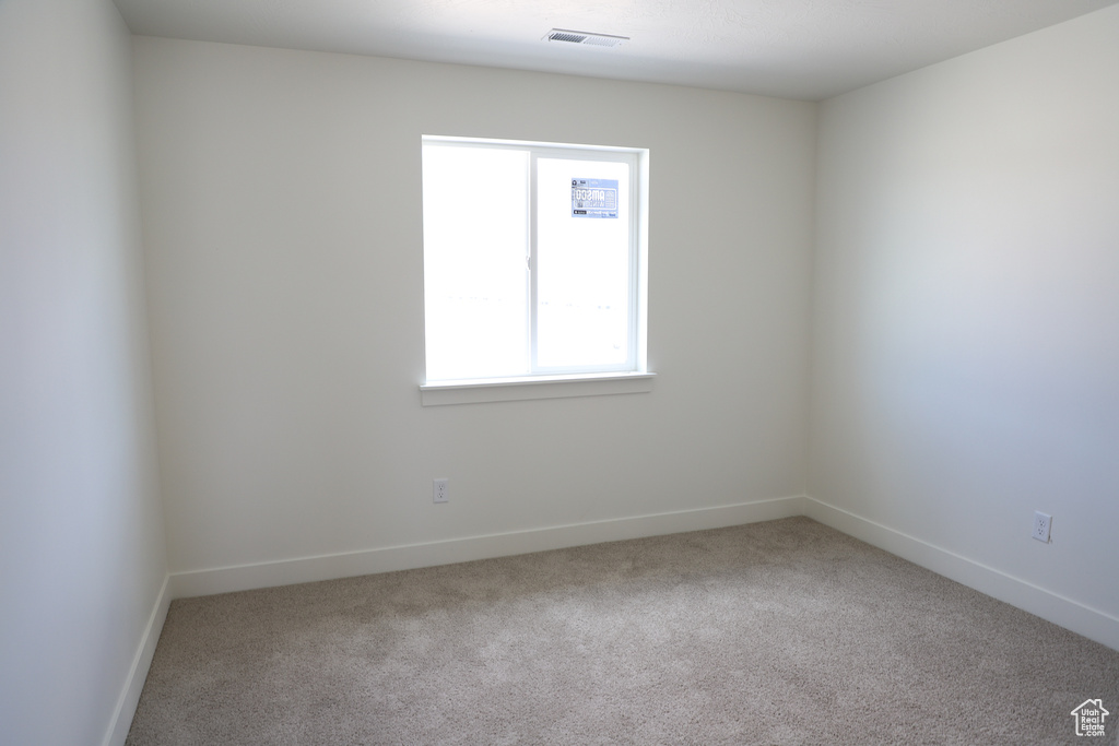 Carpeted empty room featuring baseboards