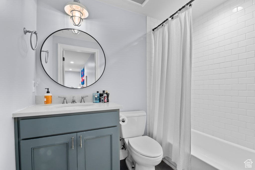 Bathroom featuring vanity, toilet, and shower / tub combo