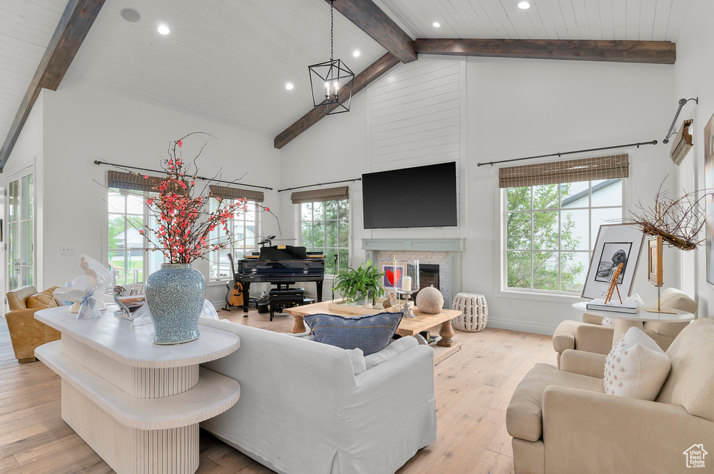 Living area featuring recessed lighting, high vaulted ceiling, hardwood / wood-style flooring, a chandelier, and a fireplace