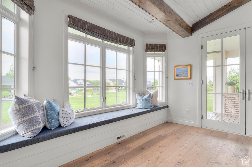 Unfurnished room with light wood finished floors, baseboards, and wood ceiling with exposed beams