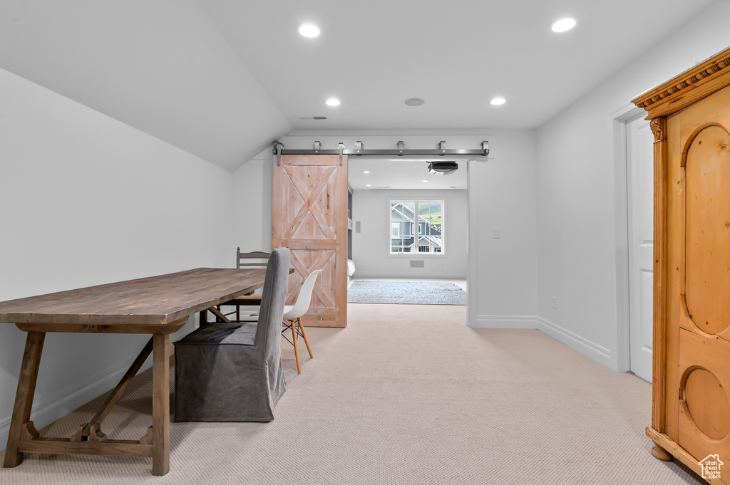 Carpeted office space with recessed lighting, a barn door, baseboards, and vaulted ceiling