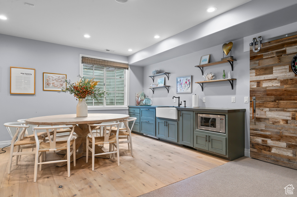 Dining space featuring bar with sink, recessed lighting, and light wood finished floors