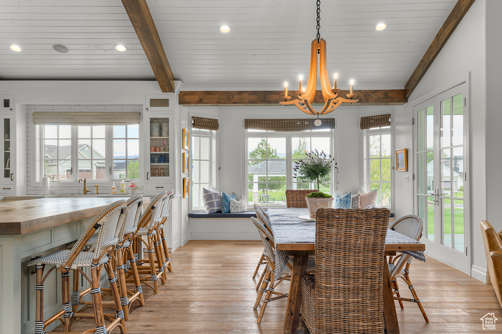 Dining room featuring light wood finished floors, a chandelier, recessed lighting, crown molding, and baseboards