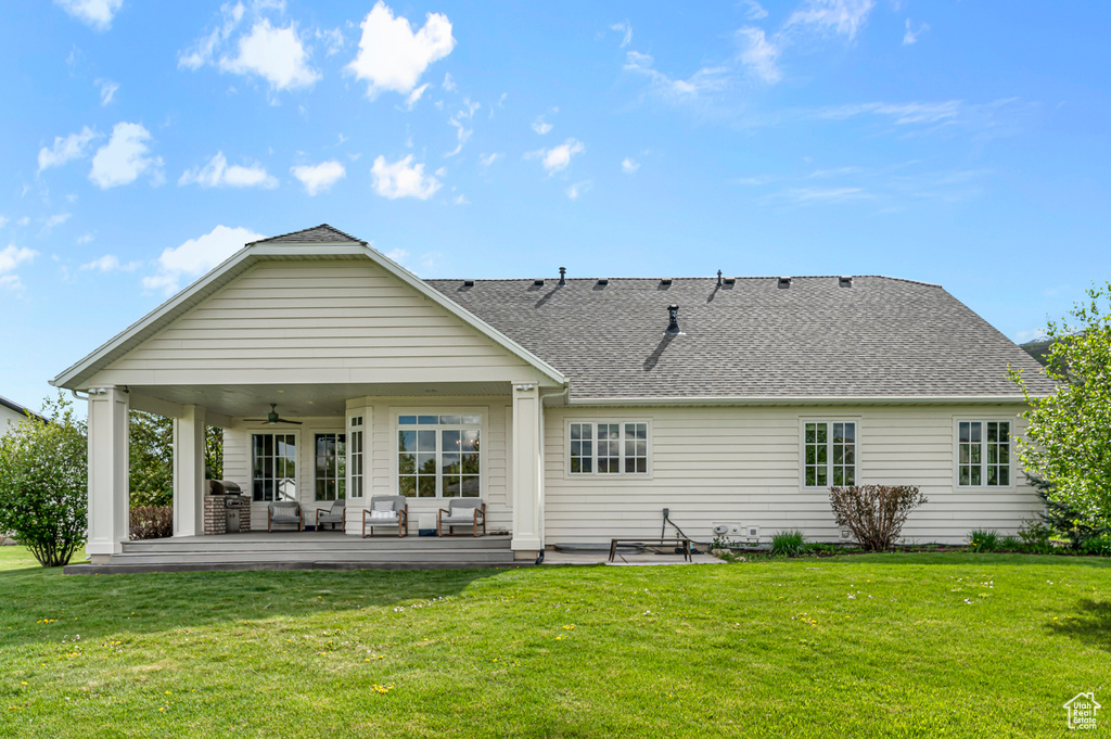 Rear view of property featuring a ceiling fan, outdoor lounge area, a yard, a shingled roof, and a patio